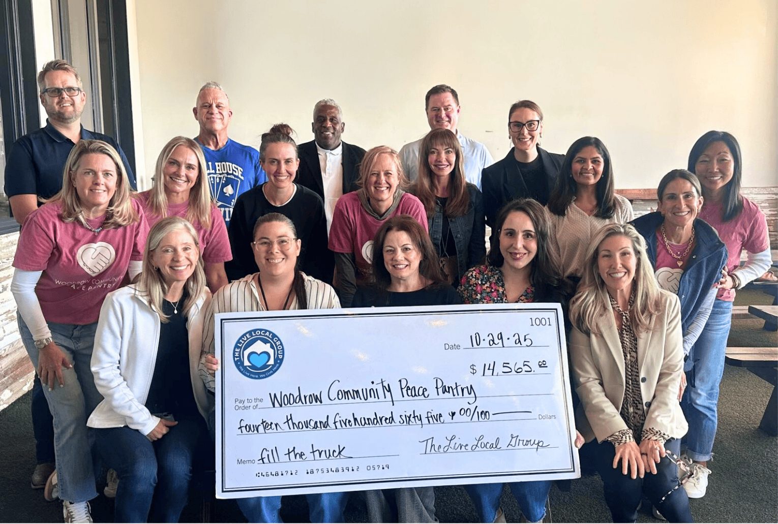 Group of Peace Pantry volunteers and sponsors holding a large donation check at Palmer’s restaurant in Dallas.